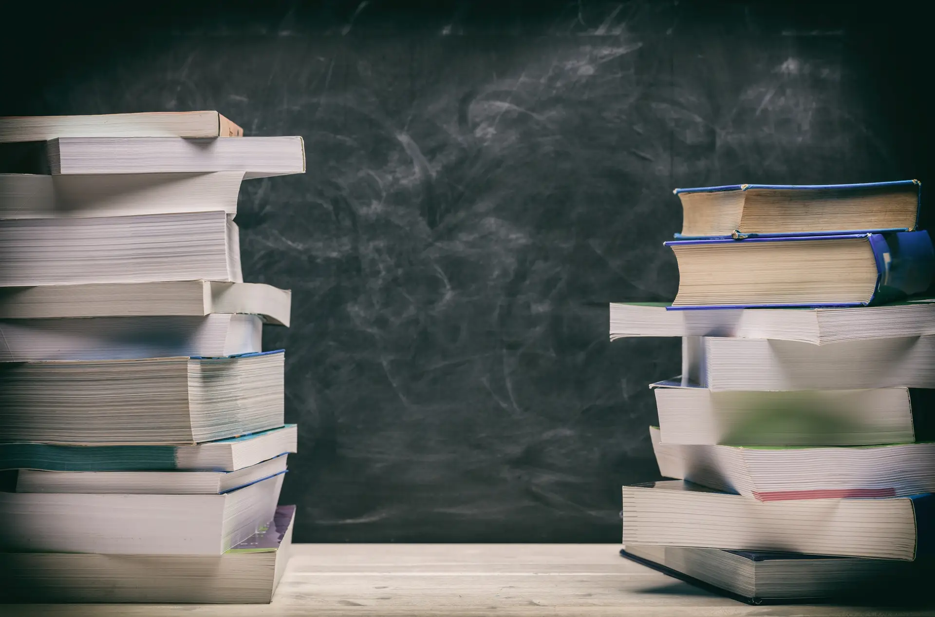 Books stacks on blackboard background