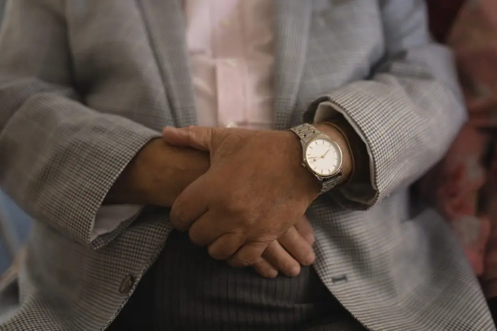 Mid section of senior man with folded hands at nursing home