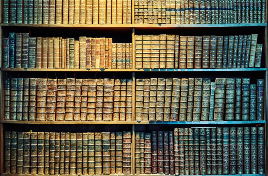 Vintage toned old books on wooden shelves.